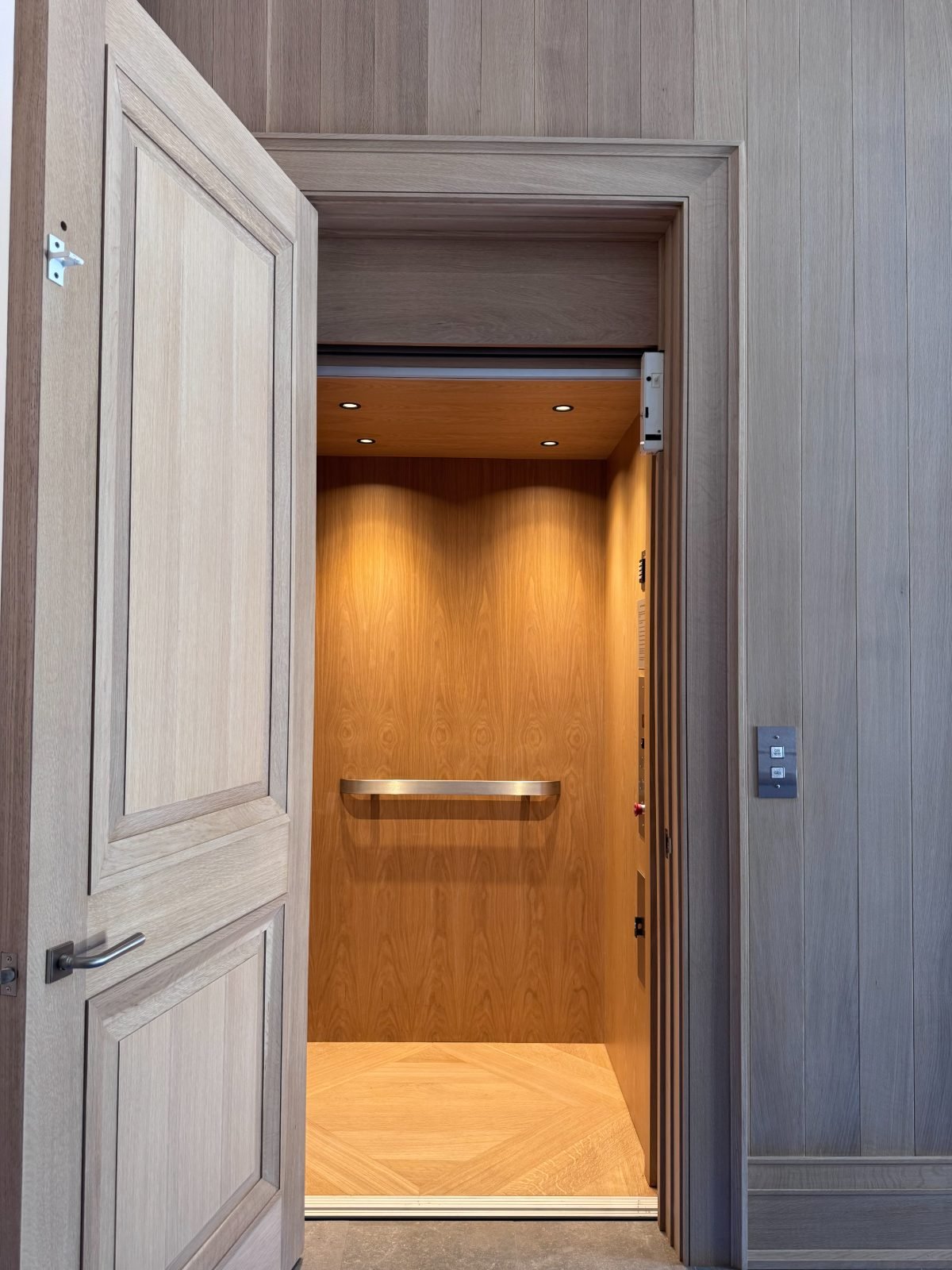 Oak-panelled cab with brass handrail in a grey-oak surround